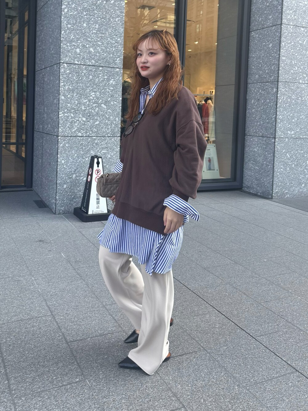 ブラウン系のスウェット、ブルー系のシャツ/ブラウス、ホワイト系のスラックスを着用したレディースの冬コーディネートの3枚目の写真