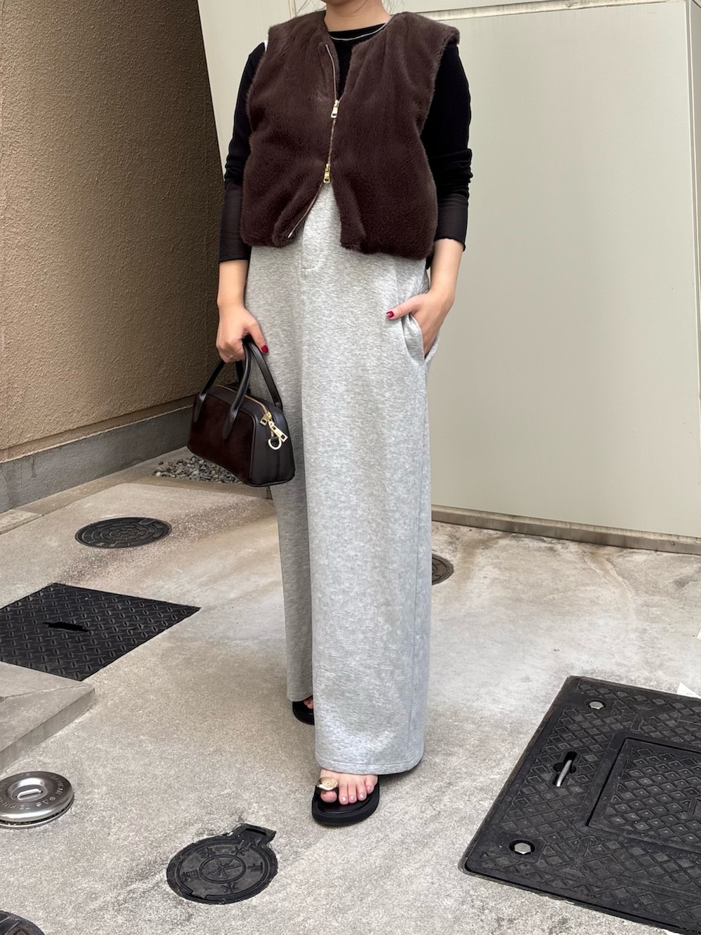 グレー系のワンピース、ブラック系のTシャツ/カットソー、ブラウン系のベストを着用したレディースの夏コーディネートの4枚目の写真