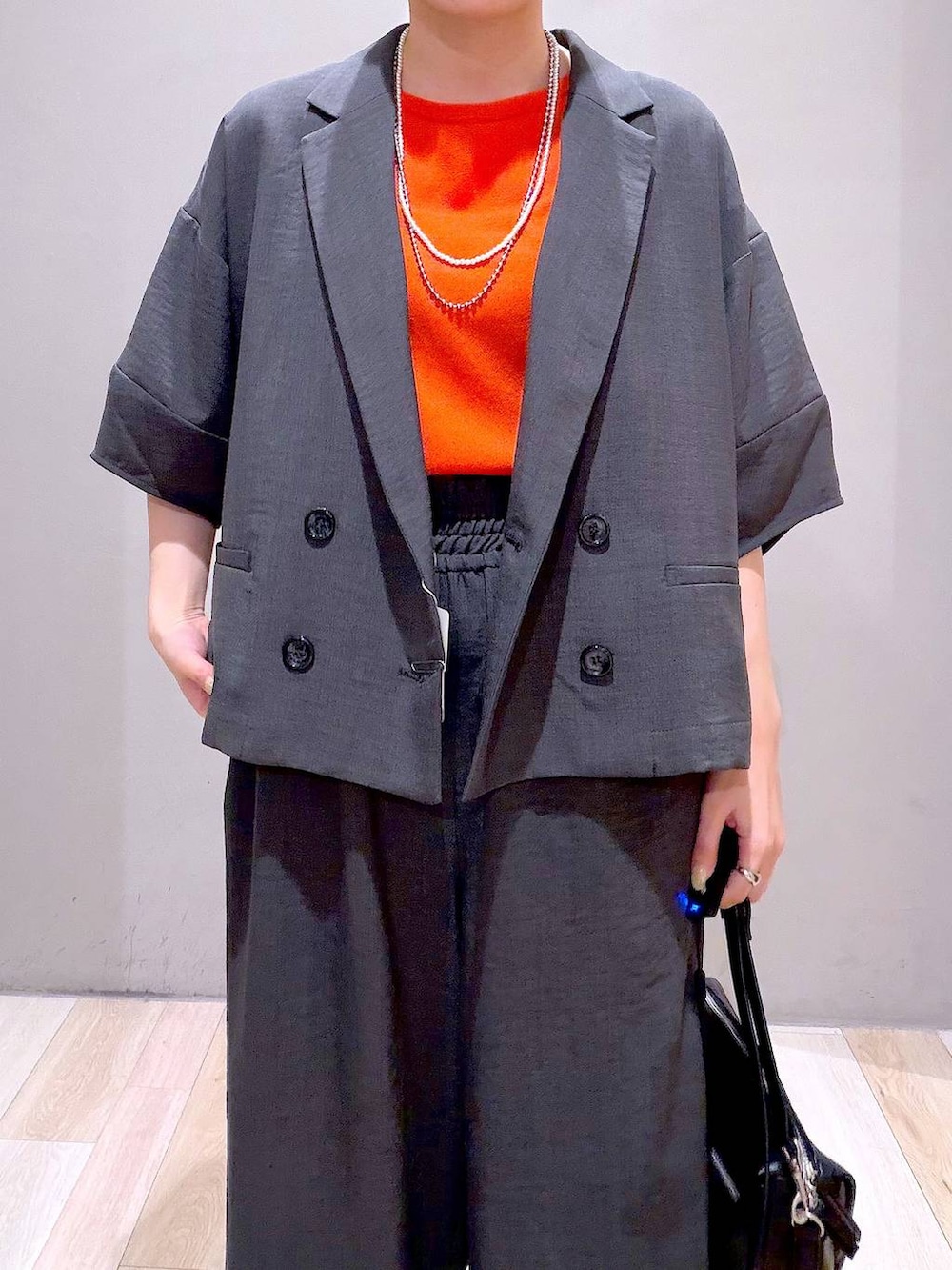 グレー系のその他パンツ、グレー系のテーラードジャケット、ブラック系のショルダーバッグを着用したレディースの春コーディネートの2枚目の写真