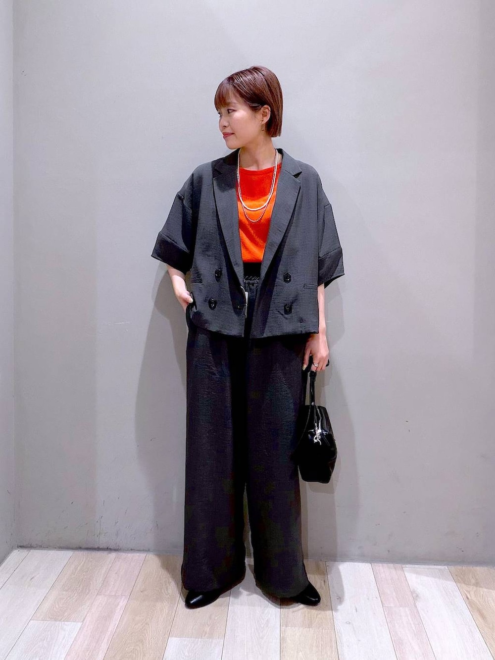 グレー系のその他パンツ、グレー系のテーラードジャケット、ブラック系のショルダーバッグを着用したレディースの春コーディネートの3枚目の写真