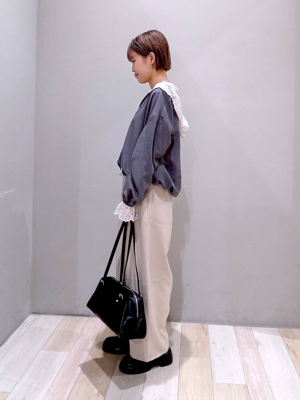 ブラック系のサンダル、ブラック系のボストンバッグ、ベージュ系のその他パンツを着用したレディースの春コーディネートの4枚目の写真