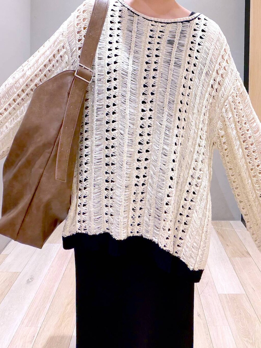 ブラック系のスカート、ブラウン系のショルダーバッグ、ブラック系のパンプスを着用したレディースの春コーディネートの3枚目の写真