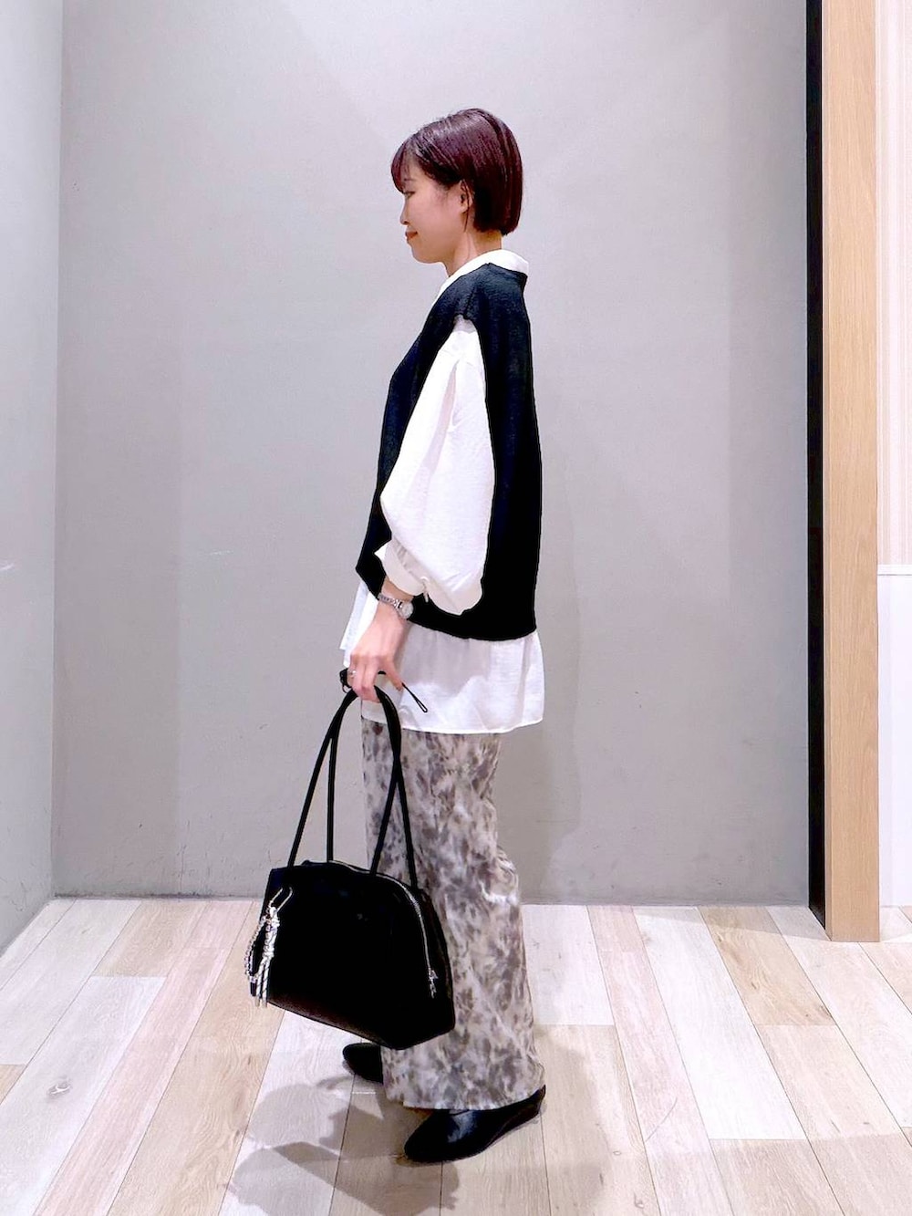 ホワイト系のシャツ/ブラウス、ブラック系のボストンバッグ、ブラック系のパンプスを着用したレディースの春コーディネートの5枚目の写真