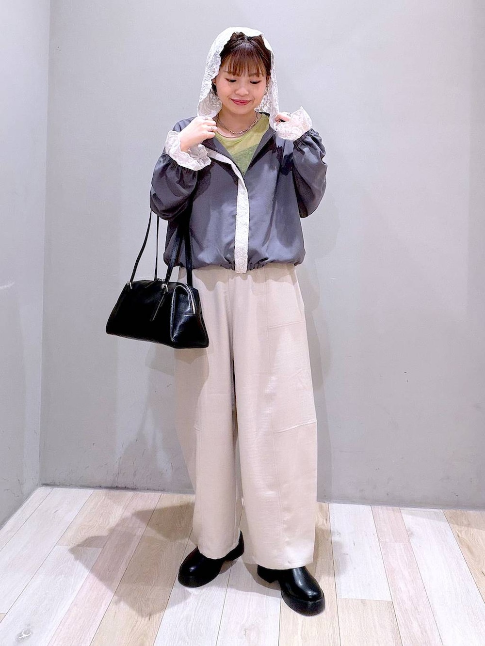 ブラック系のサンダル、ブラック系のボストンバッグ、ベージュ系のその他パンツを着用したレディースの春コーディネートの2枚目の写真