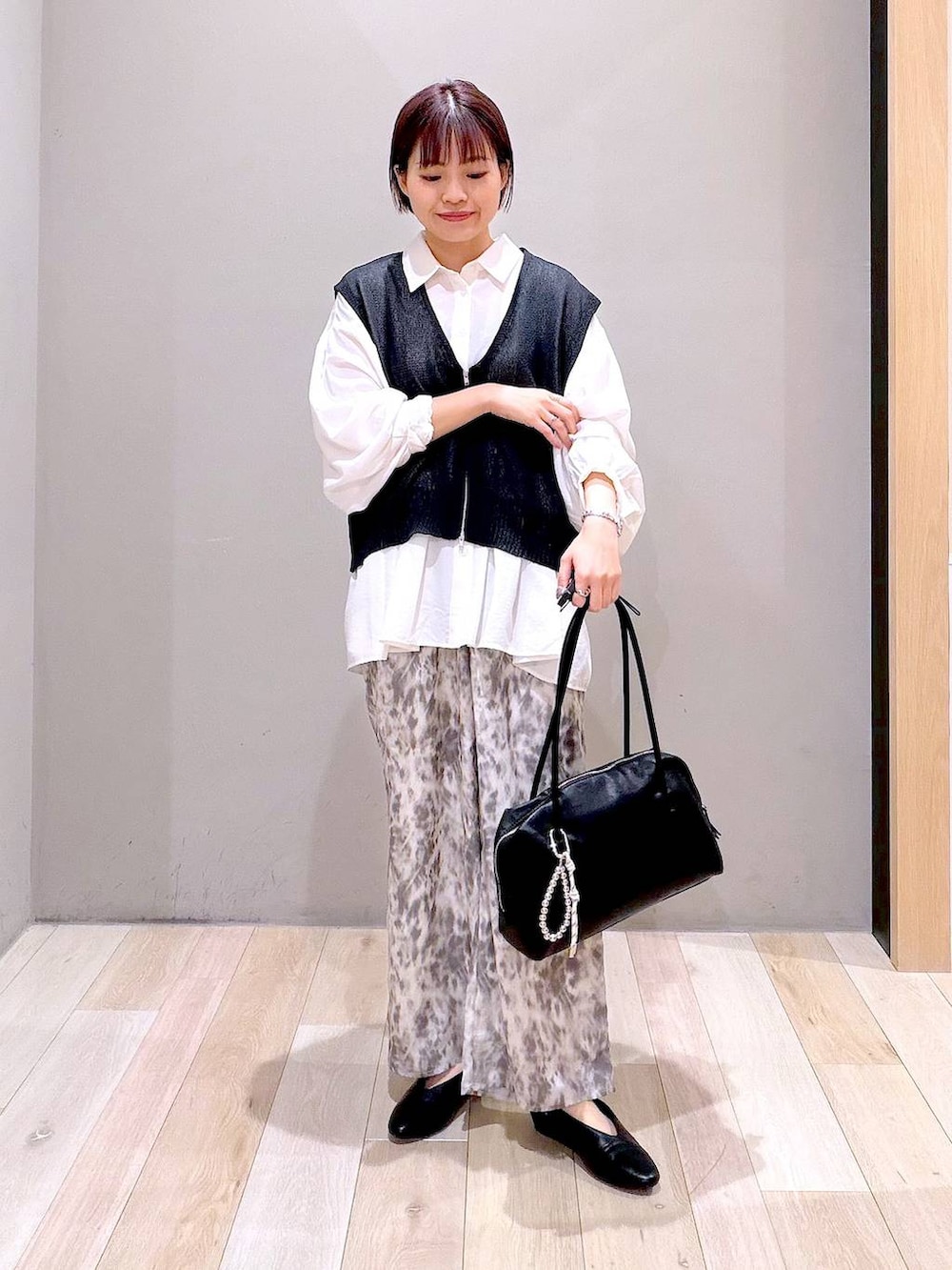 ホワイト系のシャツ/ブラウス、ブラック系のボストンバッグ、ブラック系のパンプスを着用したレディースの春コーディネートの2枚目の写真