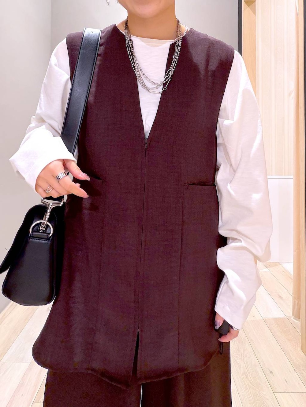 ブラック系のショルダーバッグ、ブラック系のパンプス、ブラウン系のその他パンツを着用したレディースの春コーディネートの2枚目の写真