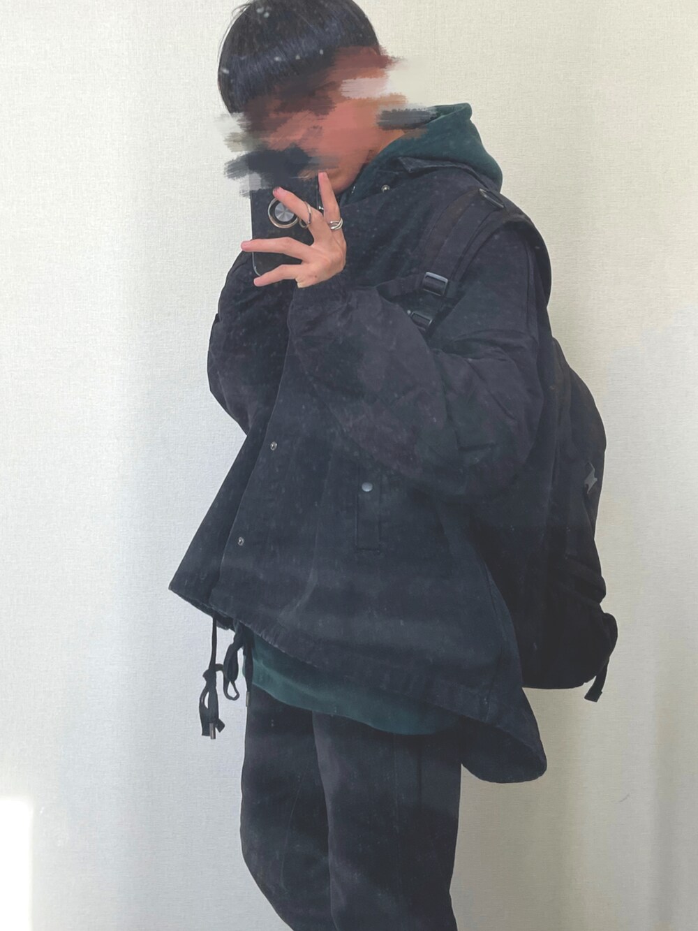 ブラック系のデニムパンツ、ブラック系のデニムジャケット、グリーン系のパーカーを着用したメンズの冬コーディネートの3枚目の写真