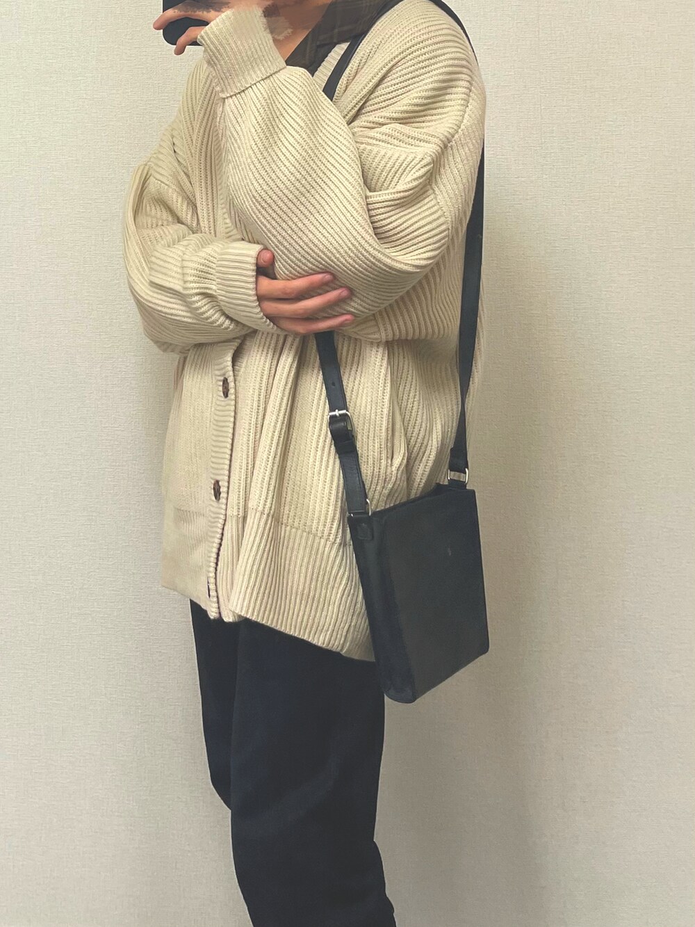 ブラック系のスラックス、ブラック系のショルダーバッグ、ホワイト系のカーディガン/ボレロを着用したメンズの春コーディネートの2枚目の写真