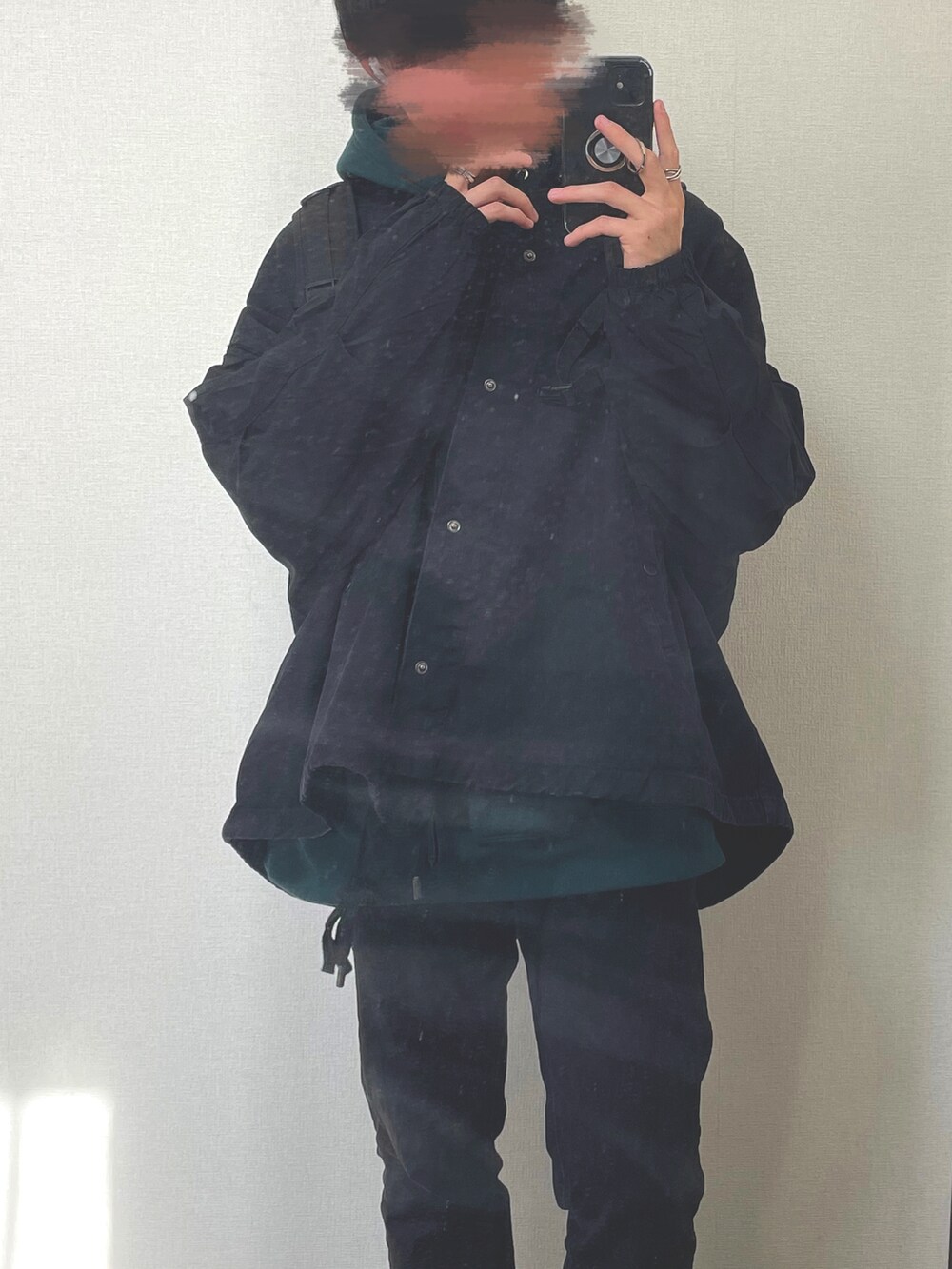 ブラック系のデニムパンツ、ブラック系のデニムジャケット、グリーン系のパーカーを着用したメンズの冬コーディネートの2枚目の写真