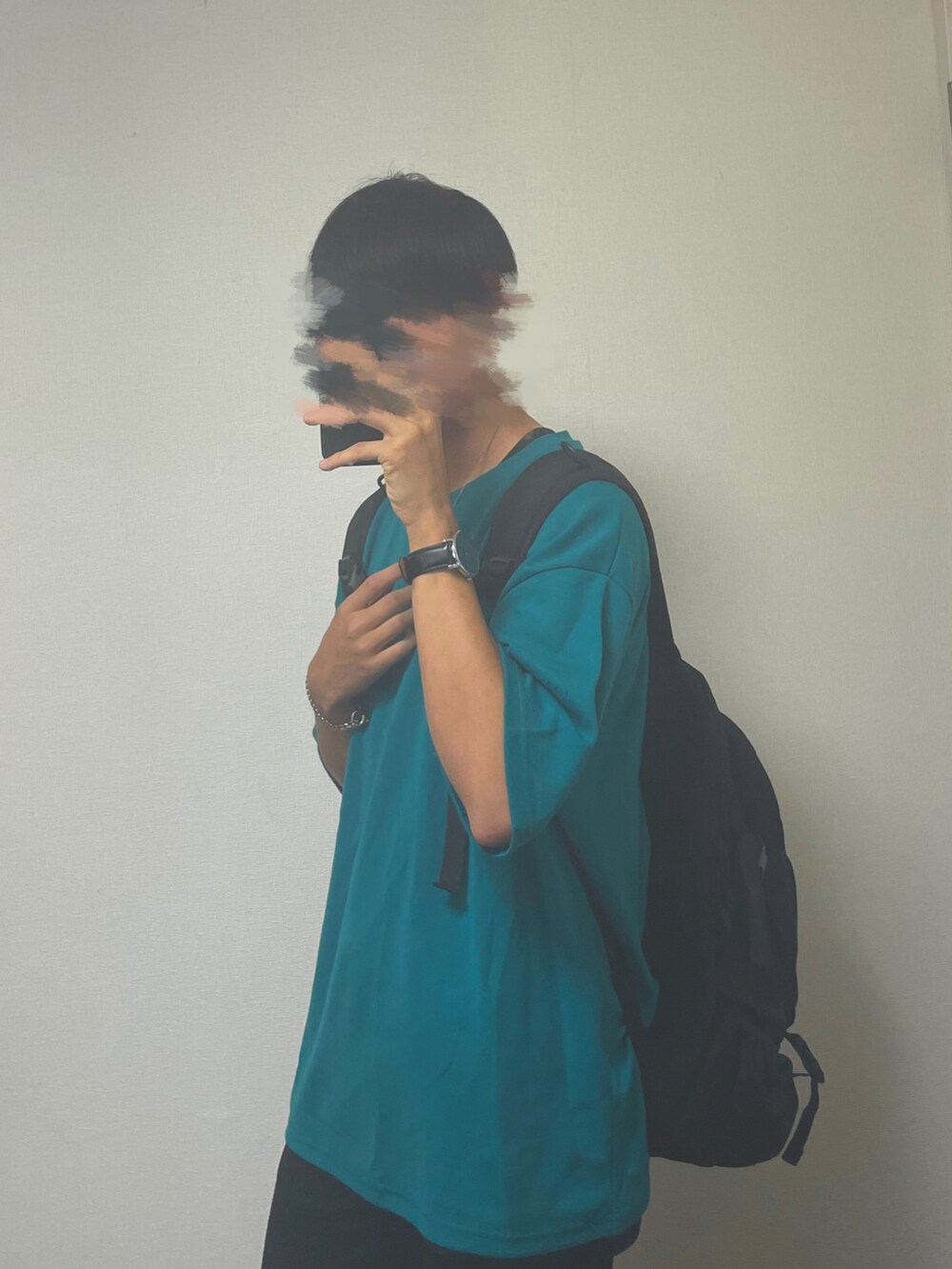 ブラック系のデニムパンツ、グリーン系のTシャツ/カットソー、ブラック系のバックパック/リュックを着用したメンズの夏コーディネートの2枚目の写真