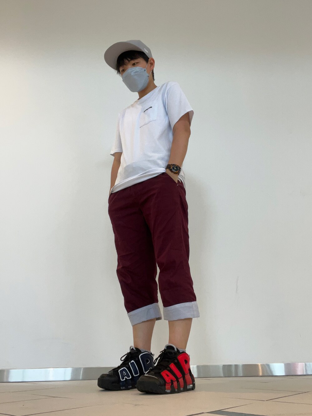 ホワイト系のTシャツ/カットソー、ブラック系のスニーカー、ブラック系のキャップを着用したレディースの夏コーディネートの2枚目の写真