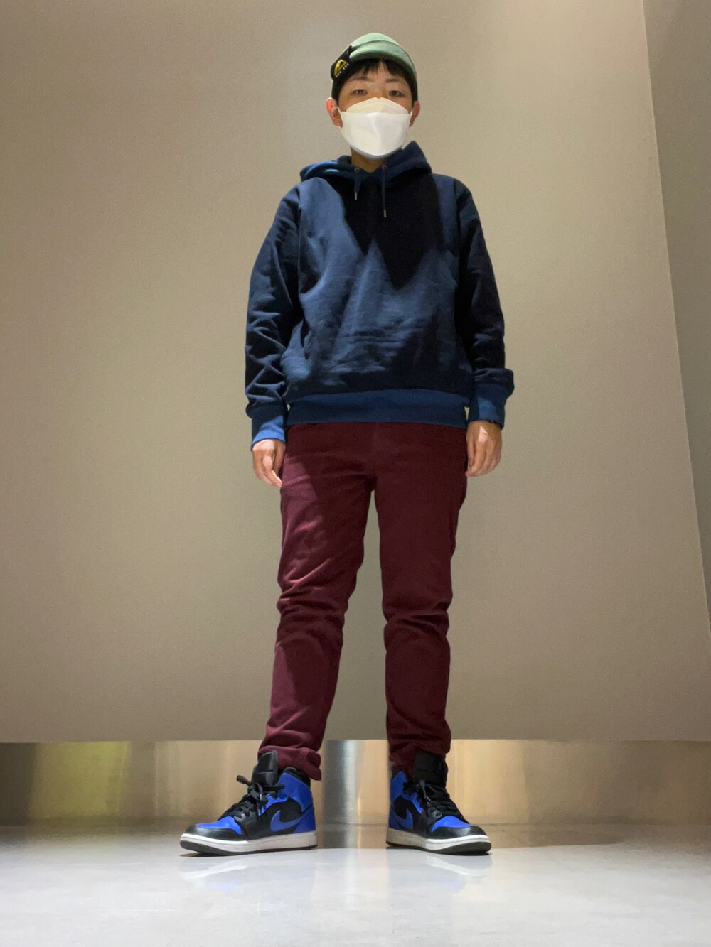 ベージュ系のブルゾン、ブラック系のパーカー、レッド系のその他パンツを着用したレディースの冬コーディネートの2枚目の写真