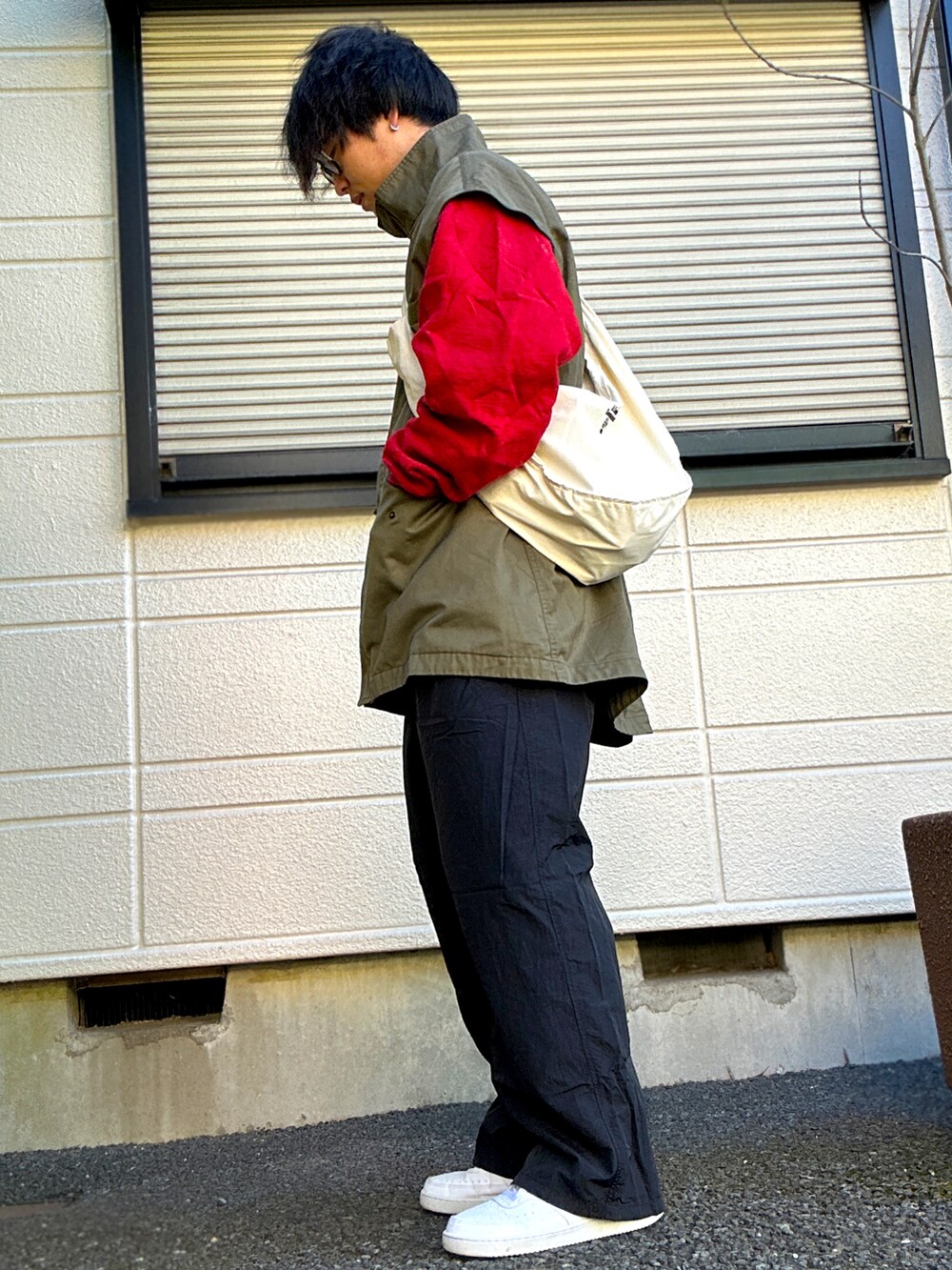 グリーン系のモッズコート、ブラック系のパンツ、ホワイト系のスニーカーを着用したメンズの冬コーディネートの2枚目の写真
