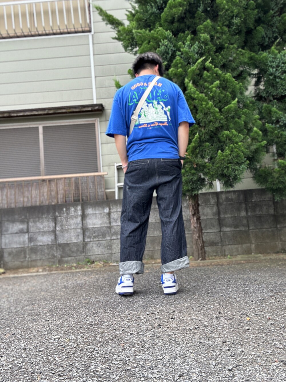ブルー系のTシャツ/カットソー、ホワイト系のショルダーバッグ、ブルー系のデニムパンツを着用したメンズの夏コーディネートの2枚目の写真