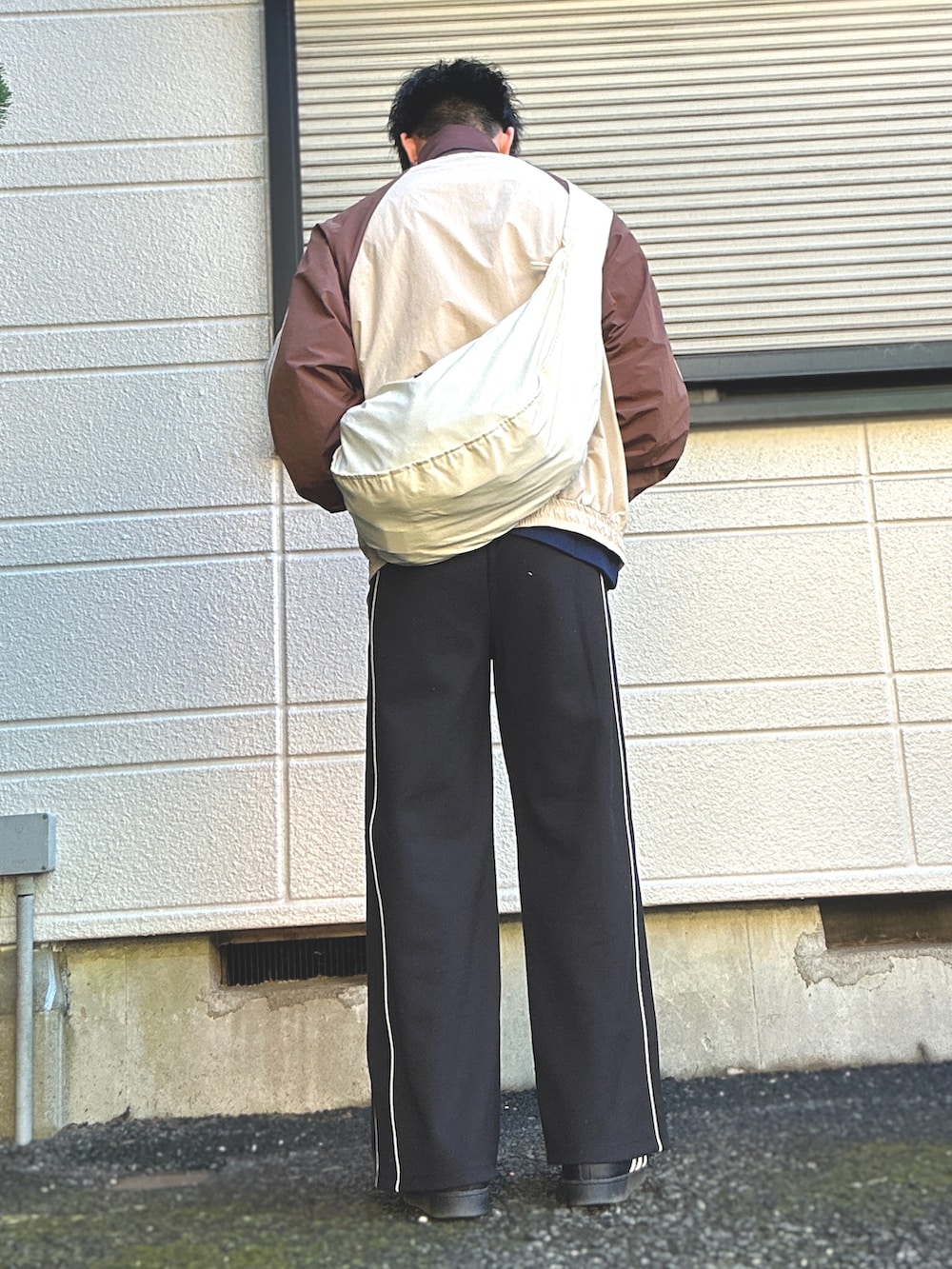 ベージュ系のジャージ、ブラック系のスニーカー、ブラック系のスウェットパンツを着用したメンズの春コーディネートの3枚目の写真
