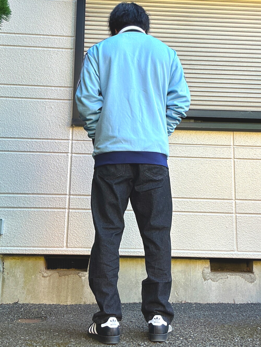 ブルー系のジャージ、ブラック系のデニムパンツ、ブラック系のスニーカーを着用したメンズの春コーディネートの3枚目の写真