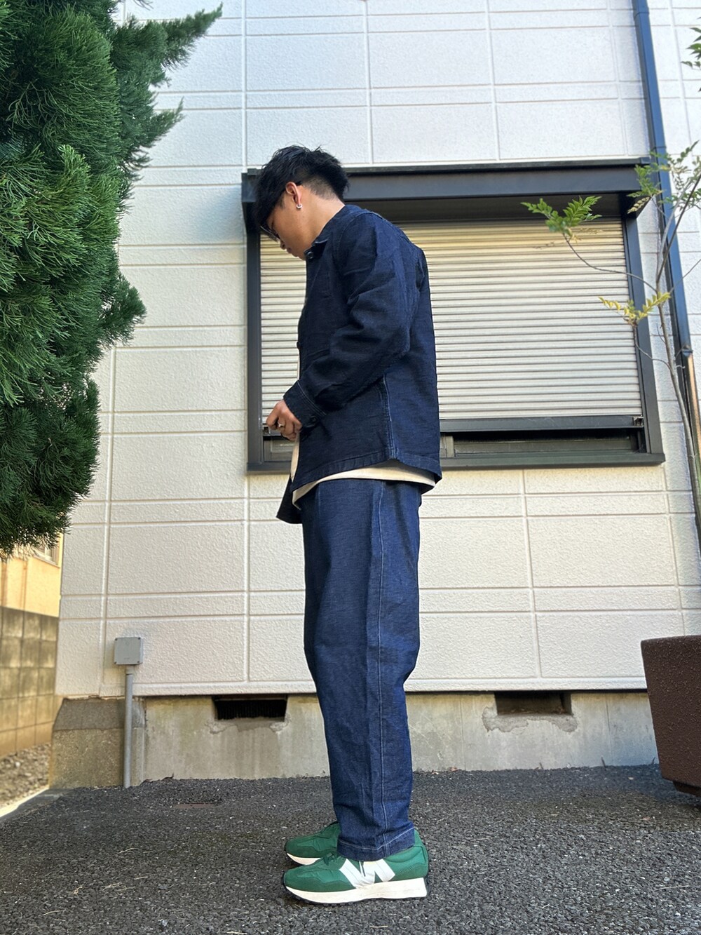 ブルー系のデニムパンツ、グリーン系のスニーカー、ベージュ系のTシャツ/カットソーを着用したメンズの冬コーディネートの2枚目の写真