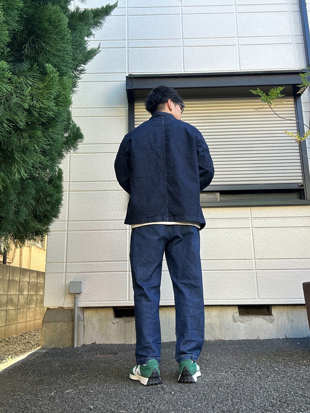 ブルー系のデニムパンツ、グリーン系のスニーカー、ベージュ系のTシャツ/カットソーを着用したメンズの冬コーディネートの3枚目の写真