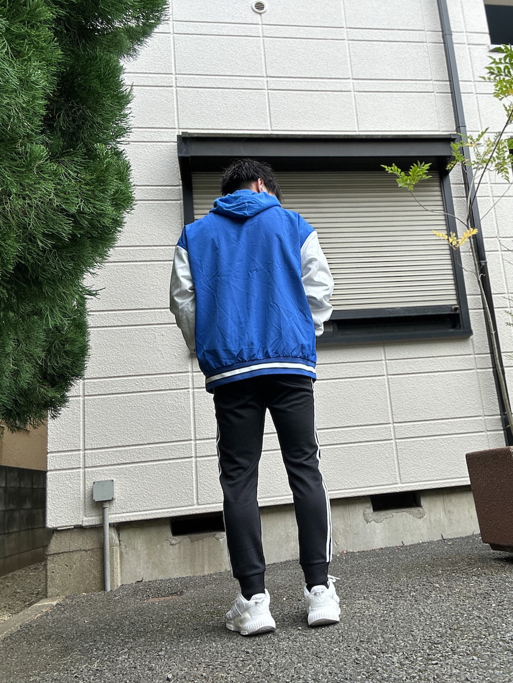 ブラック系のスウェットパンツ、ホワイト系のスニーカー、ブルー系のパーカーを着用したメンズの冬コーディネートの3枚目の写真