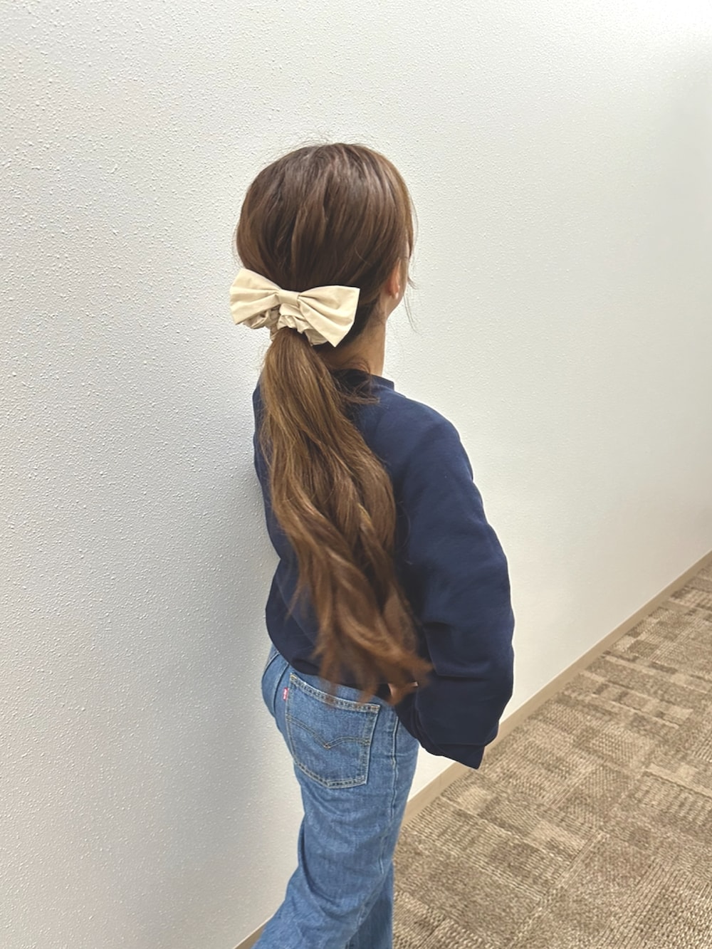 ブルー系のデニムパンツ、ホワイト系のスニーカー、ブルー系のスウェットを着用したレディースの春コーディネートの4枚目の写真