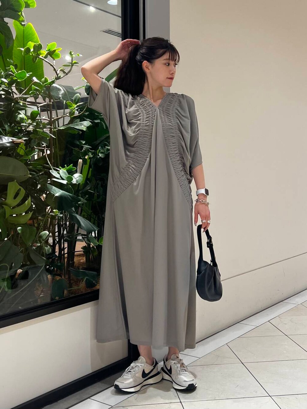 グレー系のワンピース、ホワイト系のスニーカー、ブラック系のハンドバッグを着用したレディースの夏コーディネートの6枚目の写真