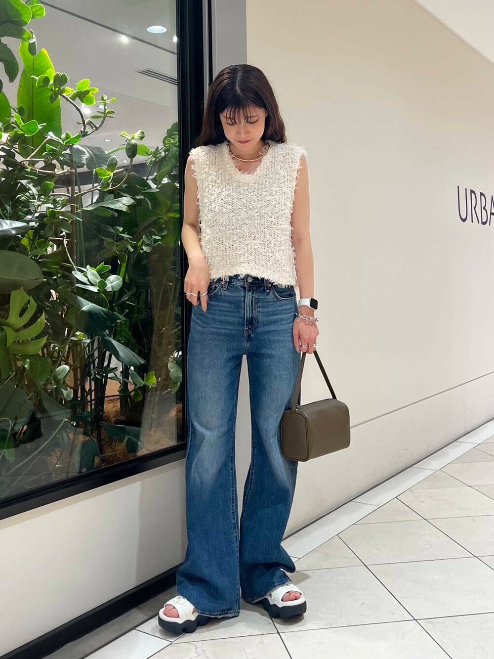 ホワイト系のサンダル、ブルー系のデニムパンツ、ベージュ系のハンドバッグを着用したレディースの夏コーディネートの5枚目の写真