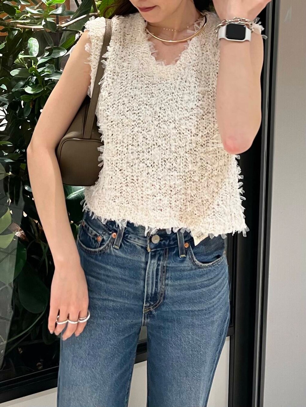 ホワイト系のサンダル、ブルー系のデニムパンツ、ベージュ系のハンドバッグを着用したレディースの夏コーディネートの7枚目の写真