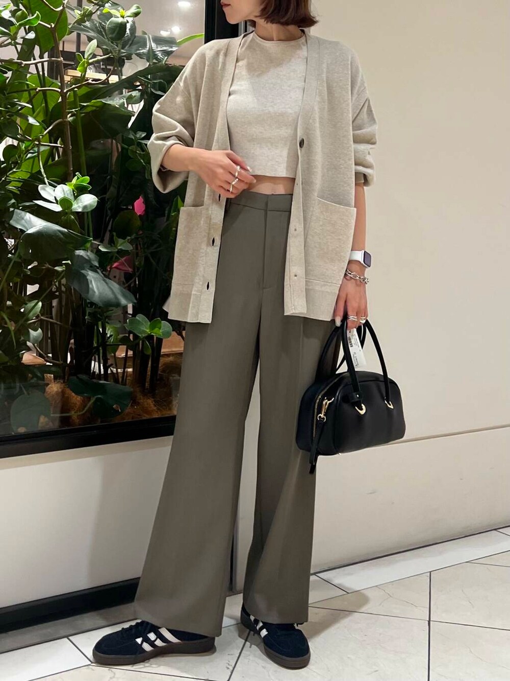 ブラック系のスニーカー、ベージュ系のカーディガン/ボレロ、ホワイト系のニット/セーターを着用したレディースの秋コーディネートの2枚目の写真