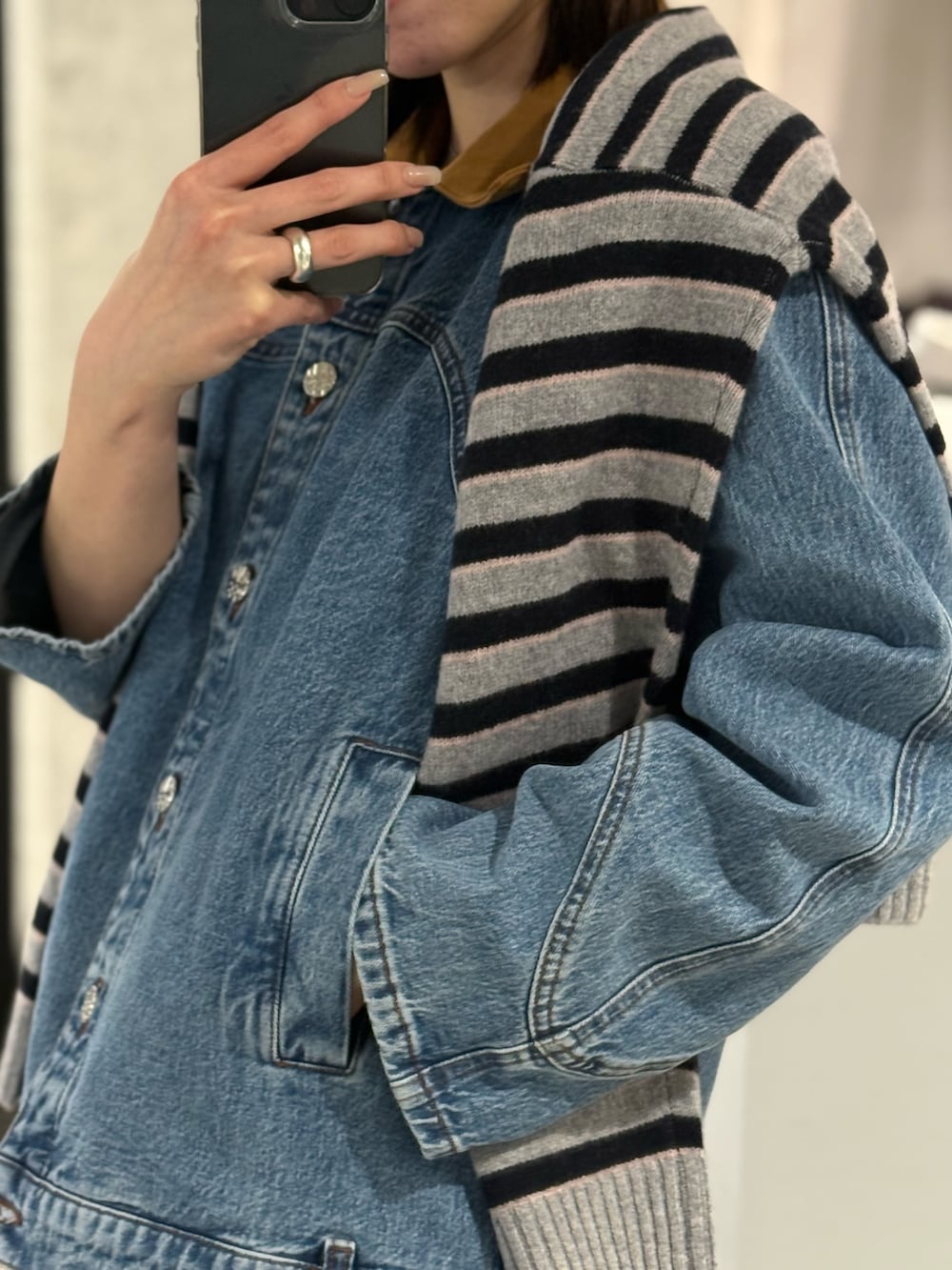 ブルー系のデニムジャケット、グレー系のニット/セーターを着用したレディースの冬コーディネートの2枚目の写真