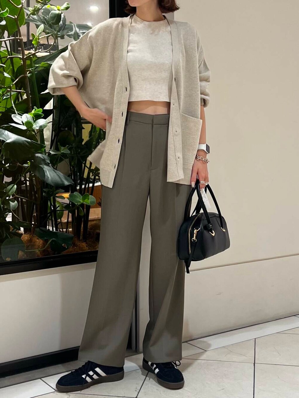 ブラック系のスニーカー、ベージュ系のカーディガン/ボレロ、ホワイト系のニット/セーターを着用したレディースの秋コーディネートの5枚目の写真