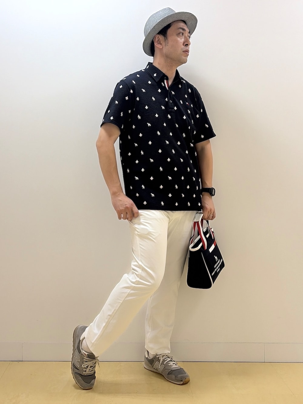ブルー系のポロシャツ、ホワイト系のその他パンツ、ブルー系のトートバッグを着用したメンズの夏コーディネートの3枚目の写真