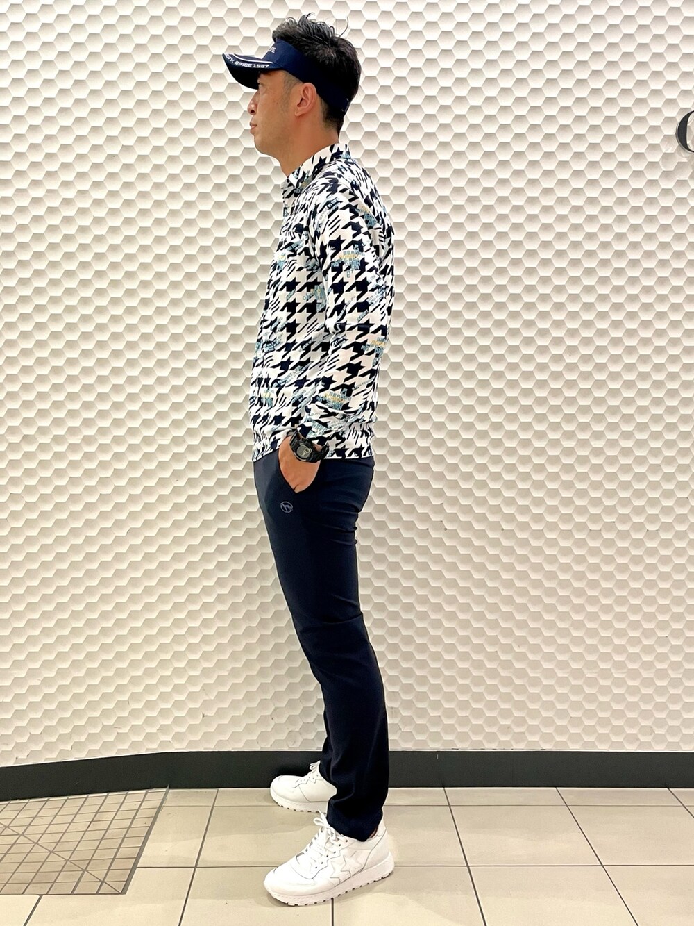 ホワイト系のポロシャツ、ブルー系のその他パンツ、ホワイト系のスニーカーを着用したメンズの秋コーディネートの3枚目の写真