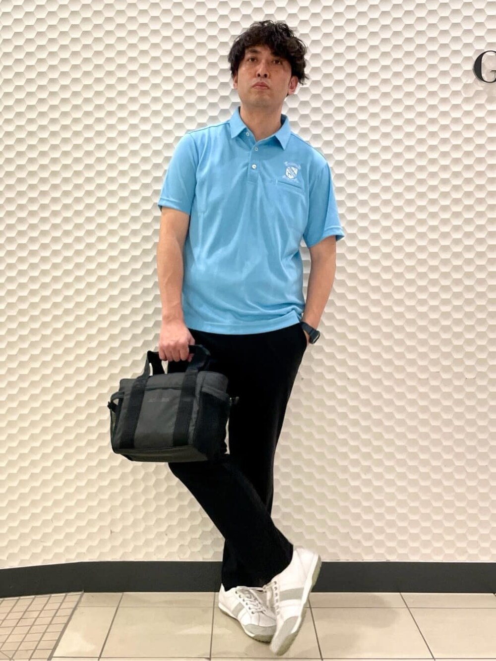 ブルー系のポロシャツ、ブラック系のその他パンツ、ブラック系のトートバッグを着用したメンズの春コーディネートの3枚目の写真
