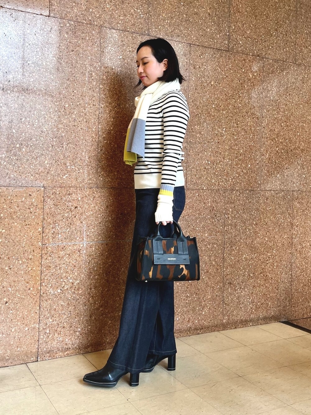 ブルー系のデニムパンツ、ホワイト系のストール/ショール、ホワイト系の手袋を着用したレディースの秋コーディネートの4枚目の写真