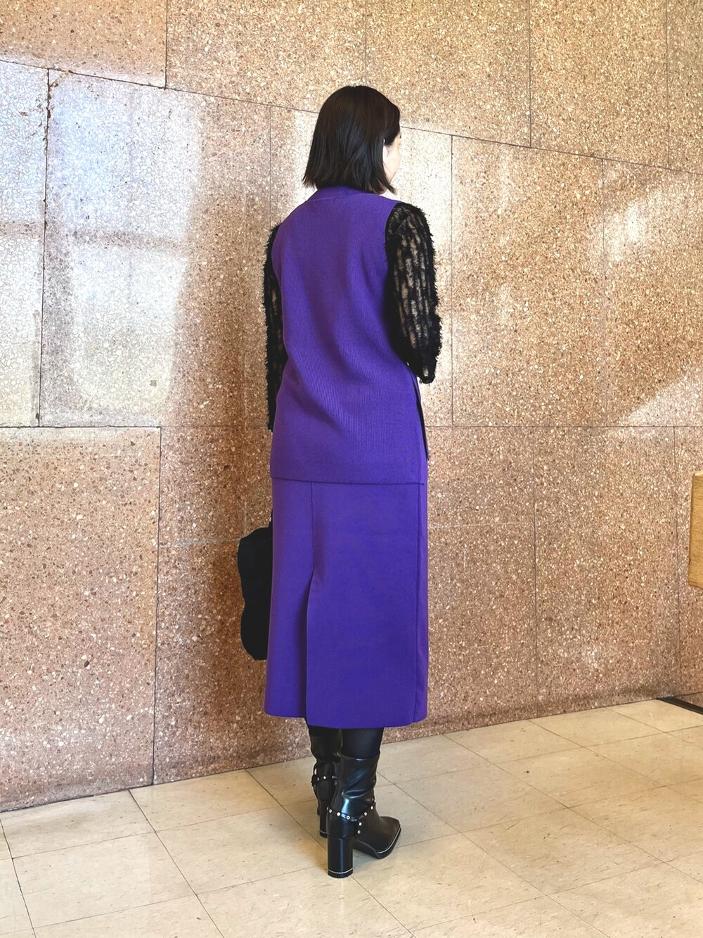 パープル系のベスト、パープル系のスカート、ブラック系のTシャツ/カットソーを着用したレディースの秋コーディネートの4枚目の写真