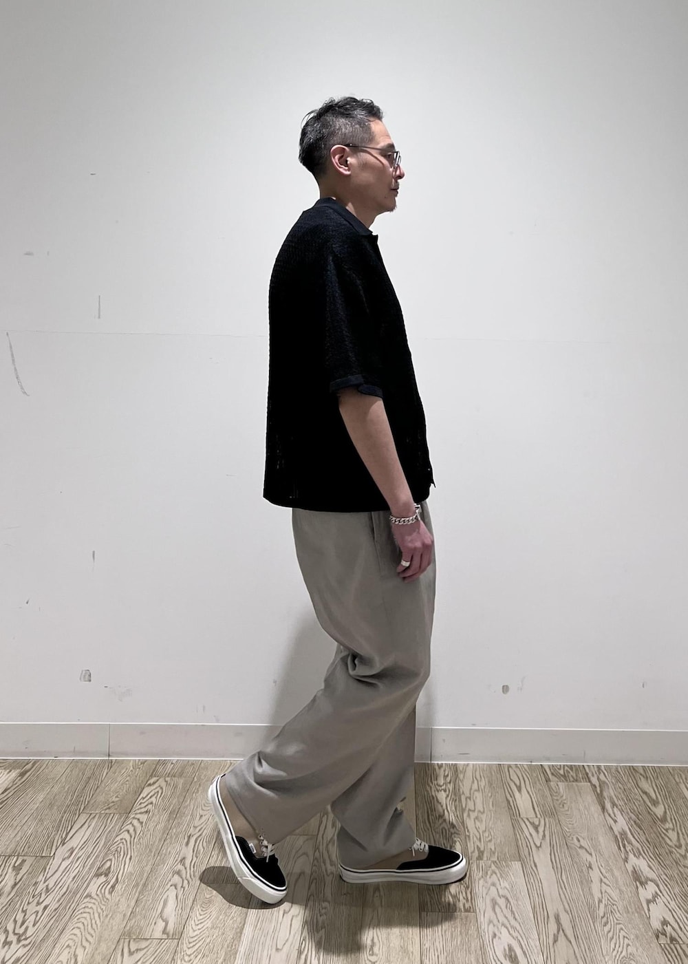 ブラック系のカーディガン/ボレロ、ホワイト系のスラックスを着用したメンズの春コーディネートの2枚目の写真