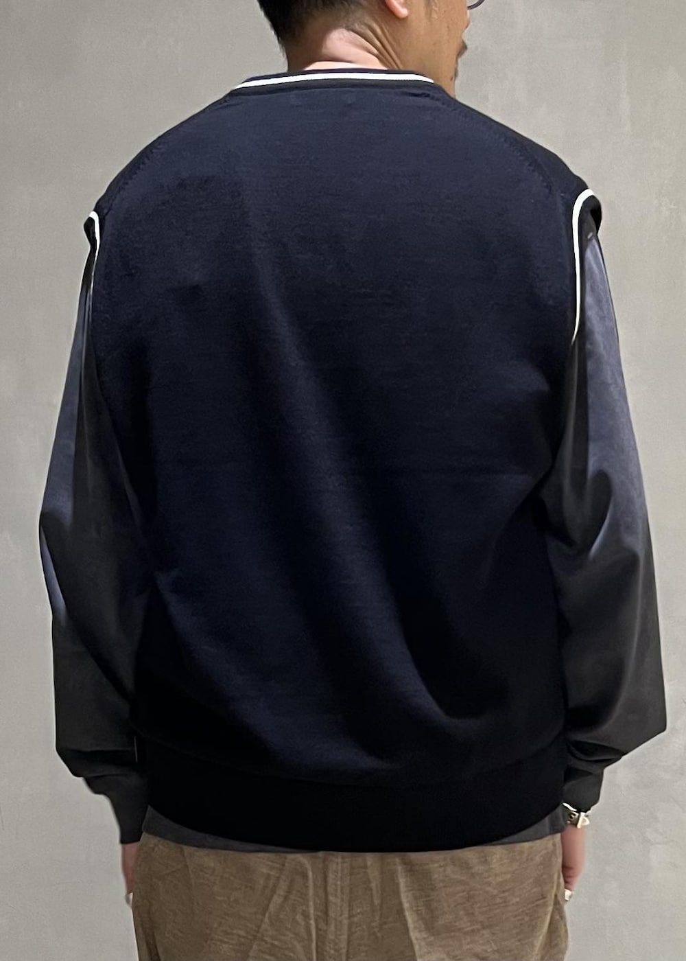ベージュ系のスラックス、グレー系のTシャツ/カットソー、ホワイト系のスニーカーを着用したメンズの秋コーディネートの6枚目の写真