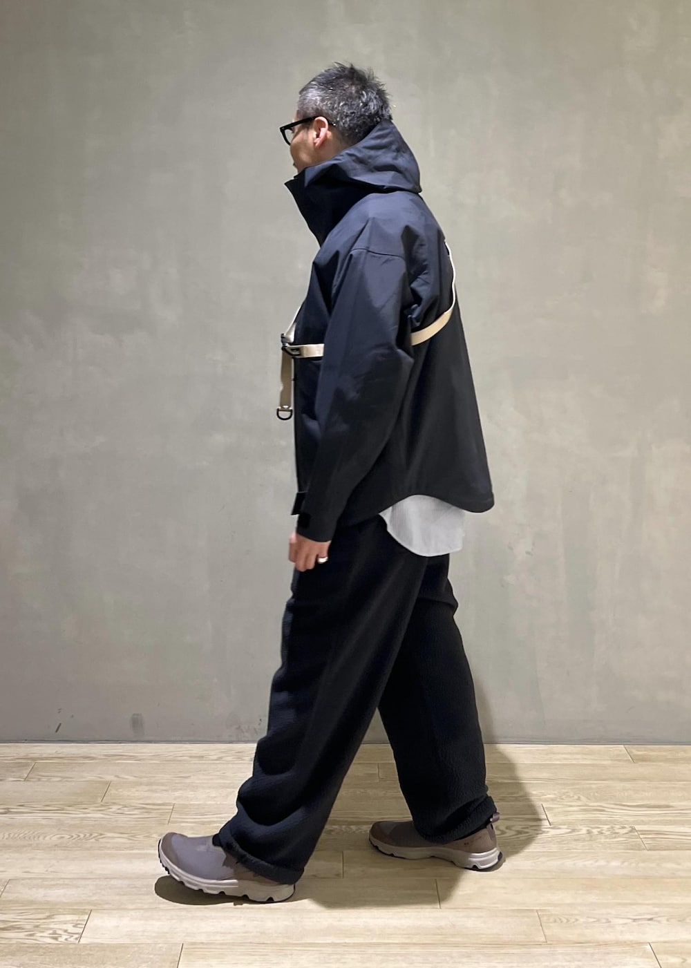 ブラック系のマウンテンパーカー、ブラック系のその他アウター、グレー系のその他パンツを着用したメンズの秋コーディネートの2枚目の写真