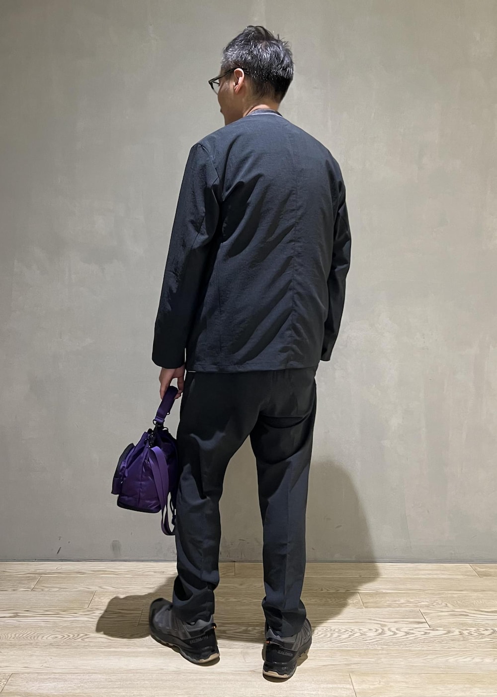 グリーン系のセットアップ、パープル系のショルダーバッグ、グレー系のTシャツ/カットソーを着用したメンズの秋コーディネートの3枚目の写真