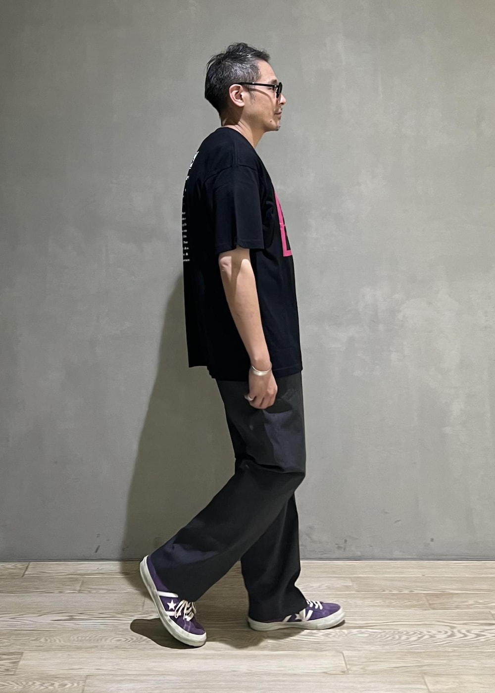 グレー系のスラックス、ブラック系のTシャツ/カットソーを着用したメンズの夏コーディネートの2枚目の写真