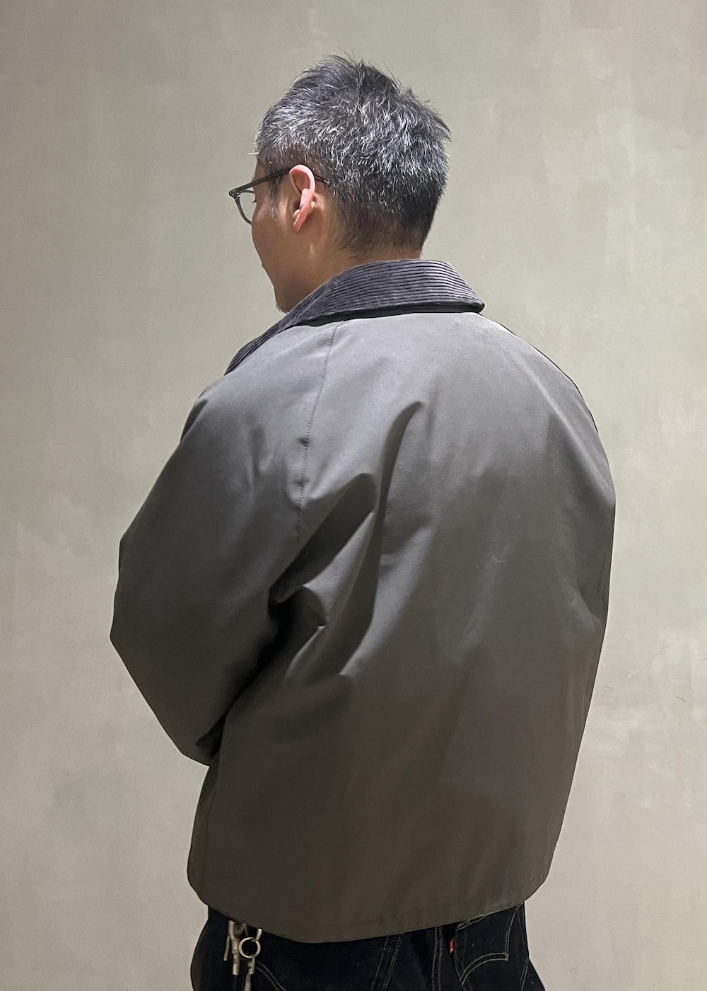 ブルー系のデニムパンツ、グレー系のブルゾン、ベージュ系のニット/セーターを着用したメンズの冬コーディネートの6枚目の写真