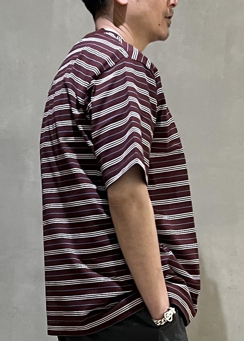 グレー系のスラックス、レッド系のTシャツ/カットソーを着用したメンズの春コーディネートの6枚目の写真