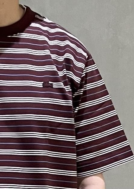 グレー系のスラックス、レッド系のTシャツ/カットソーを着用したメンズの春コーディネートの5枚目の写真