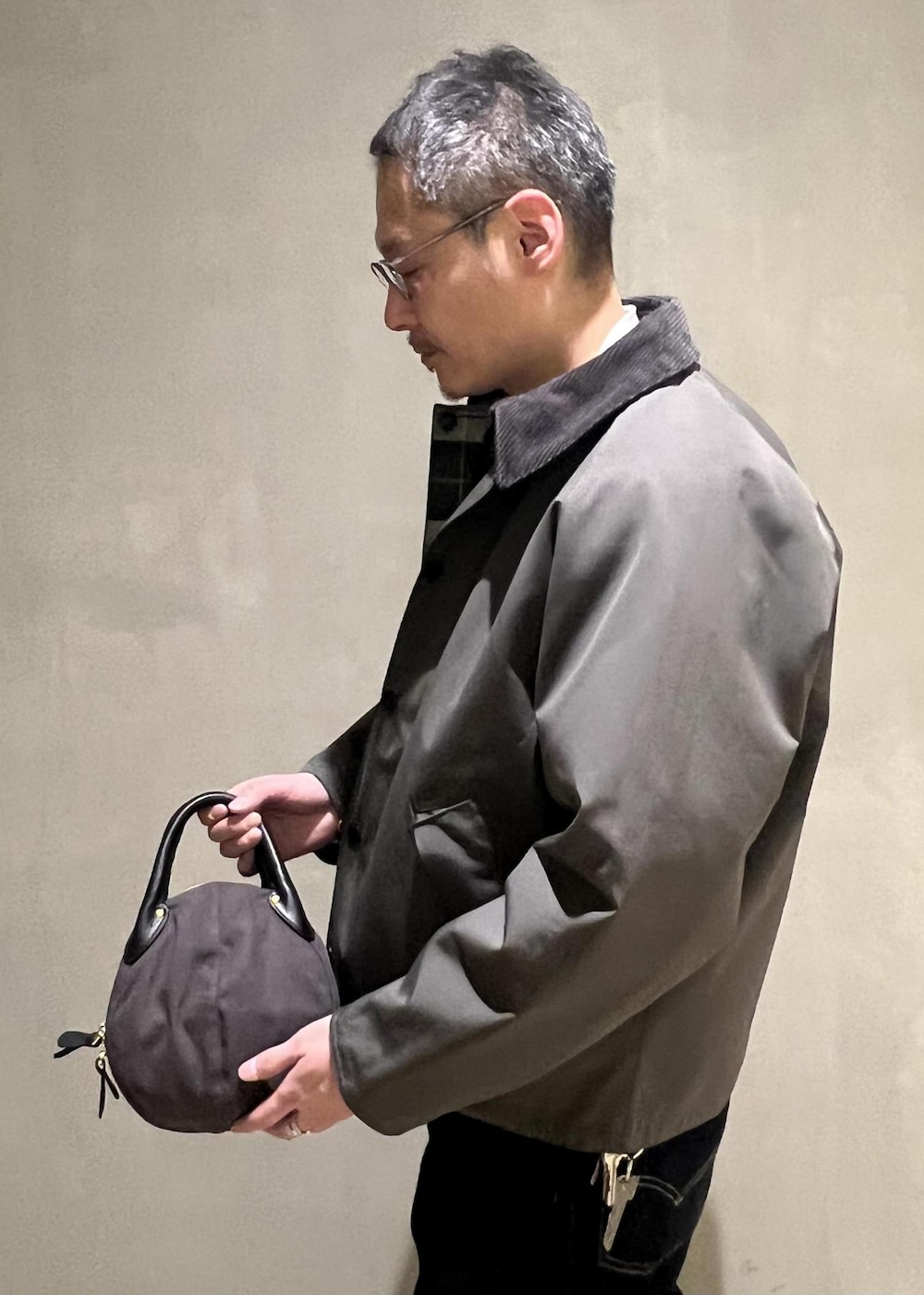 ブルー系のデニムパンツ、グレー系のブルゾン、ベージュ系のニット/セーターを着用したメンズの冬コーディネートの5枚目の写真