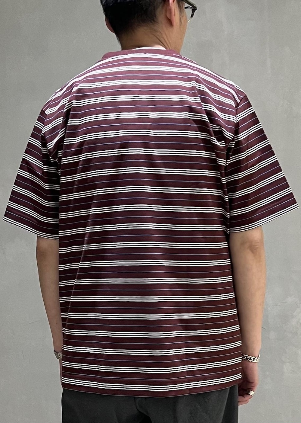 グレー系のスラックス、レッド系のTシャツ/カットソーを着用したメンズの春コーディネートの7枚目の写真