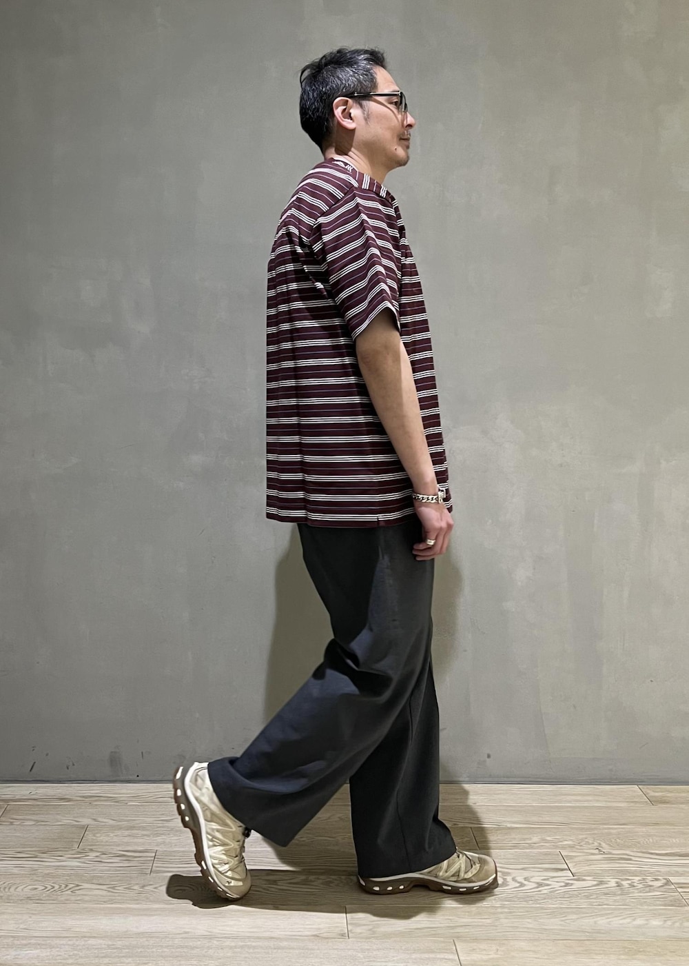 グレー系のスラックス、レッド系のTシャツ/カットソーを着用したメンズの春コーディネートの2枚目の写真