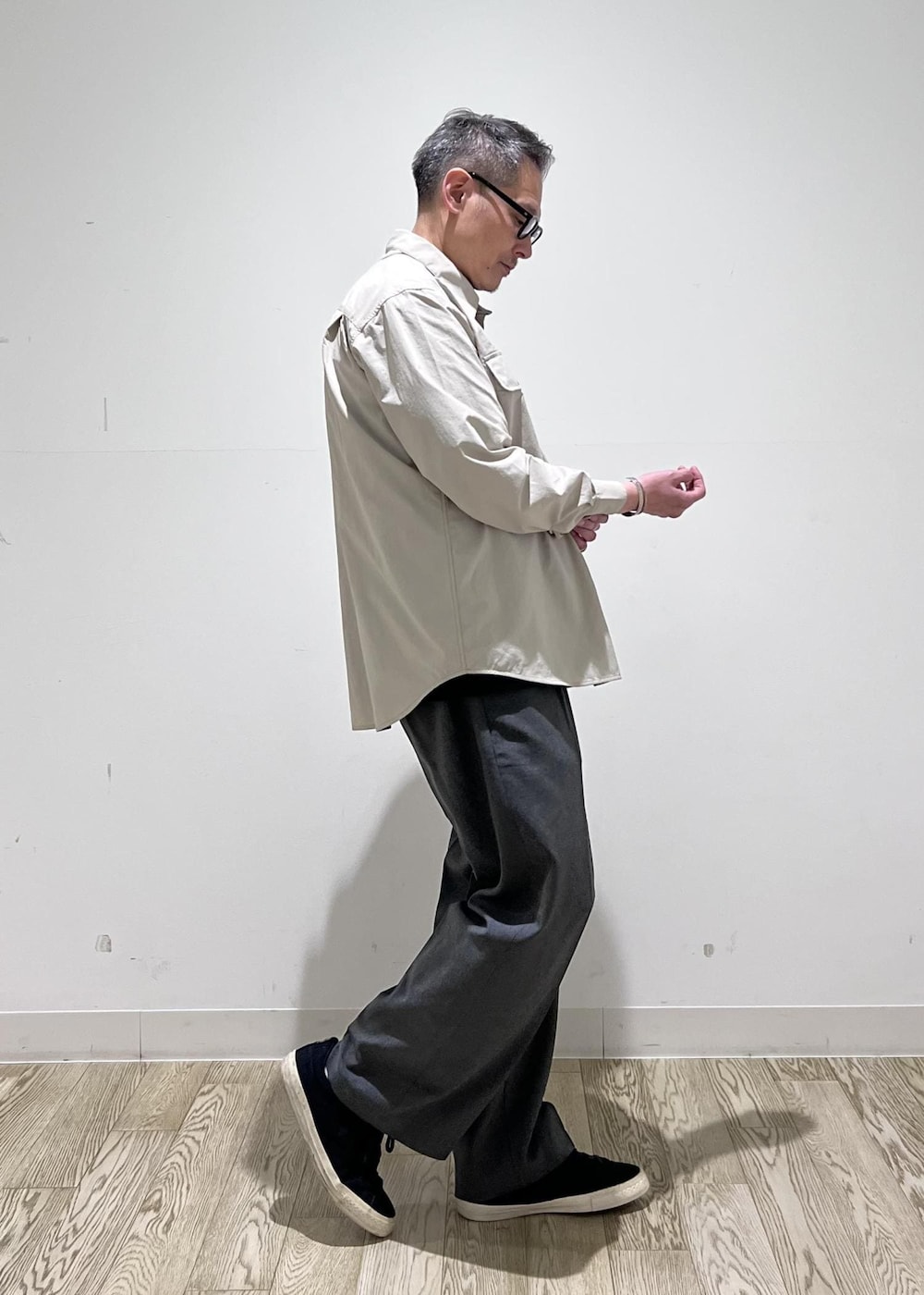 グレー系のスラックス、ベージュ系のシャツ/ブラウスを着用したメンズの春コーディネートの2枚目の写真