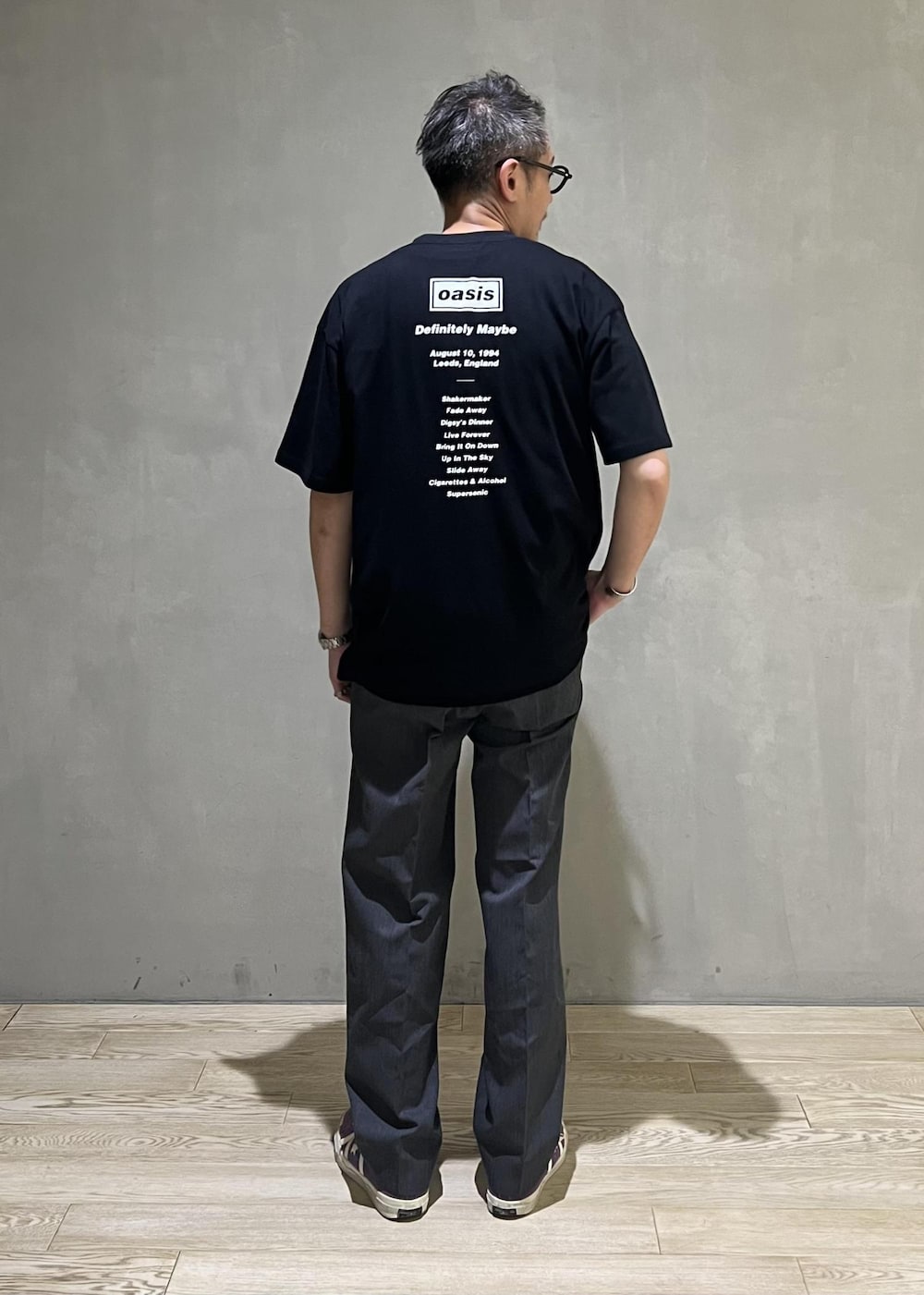 グレー系のスラックス、ブラック系のTシャツ/カットソーを着用したメンズの夏コーディネートの3枚目の写真