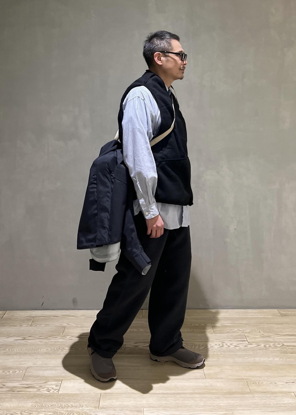 ブラック系のマウンテンパーカー、ブラック系のその他アウター、グレー系のその他パンツを着用したメンズの秋コーディネートの8枚目の写真