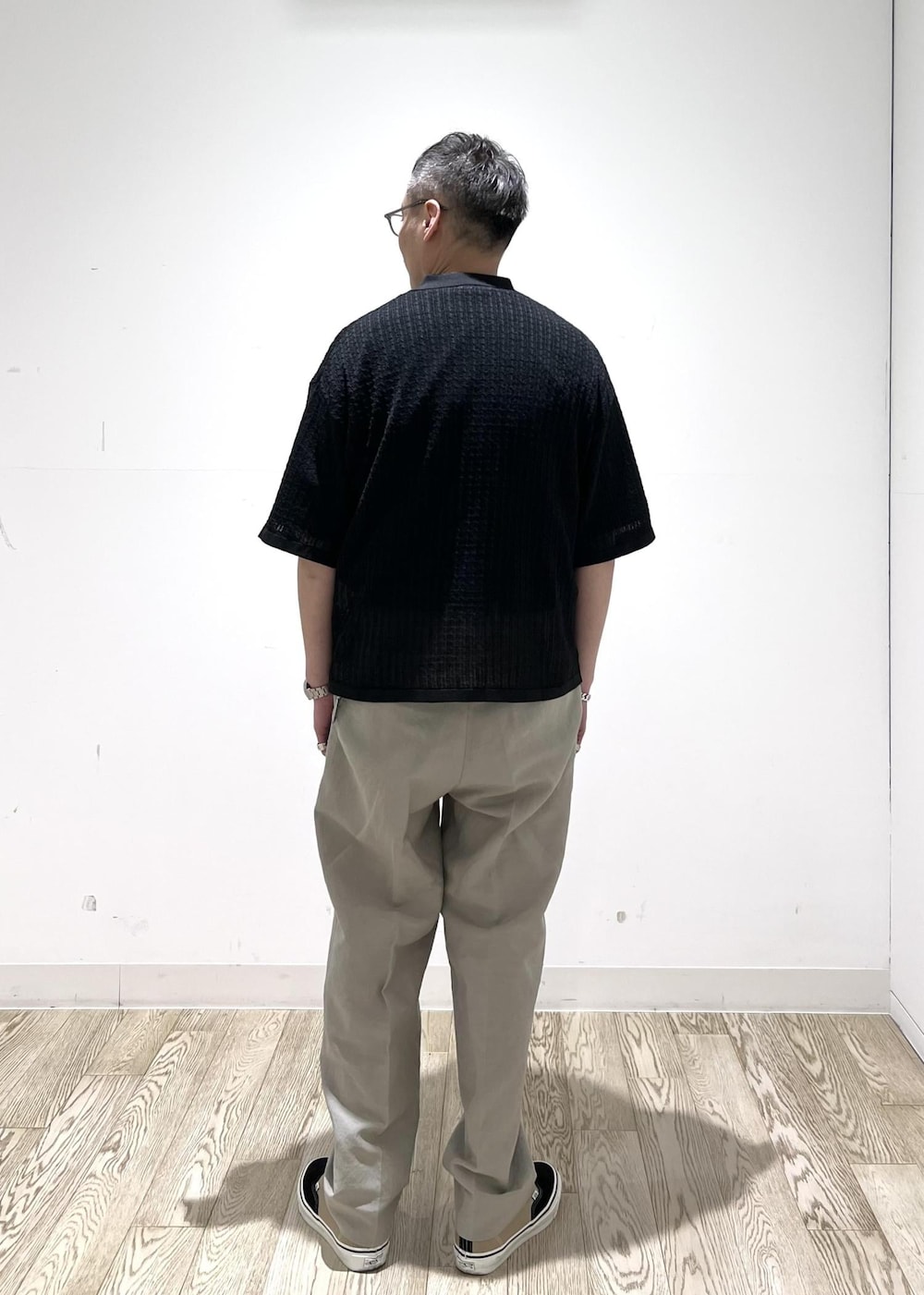 ブラック系のカーディガン/ボレロ、ホワイト系のスラックスを着用したメンズの春コーディネートの3枚目の写真